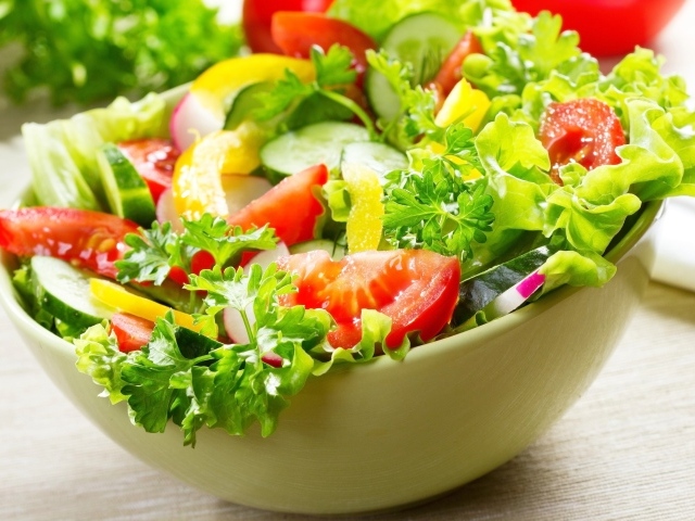 Салат из свежих овощей с зеленью на столе