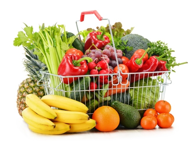 Железная корзина со свежими овощами и фруктами на белом фоне