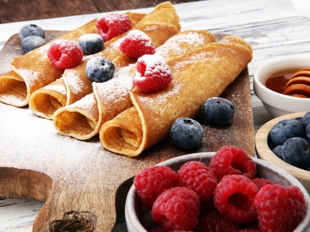 Блинчики с ягодами черники, малиной и сахарной пудрой