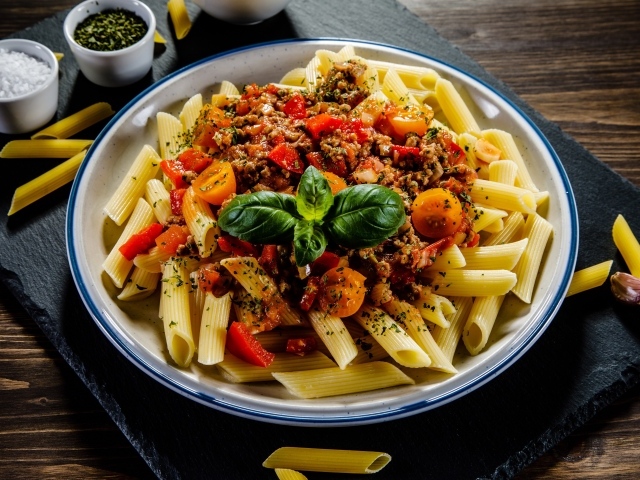 Макароны с фаршем и помидорами на столе