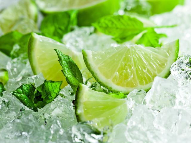 Кусочки свежего лайма с листьями мяты лежат на льду