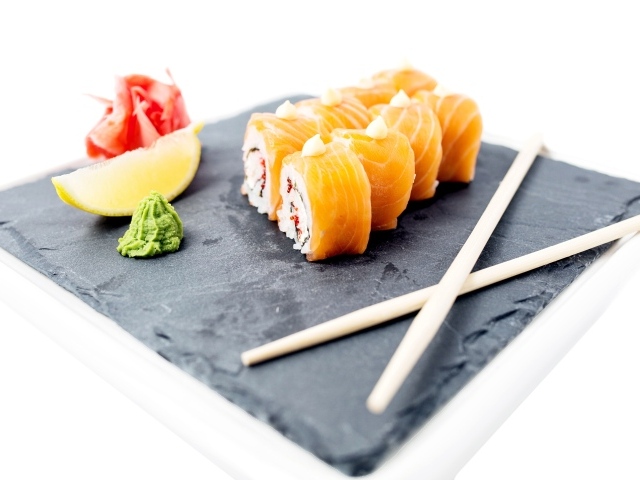 Роллы с красной рыбой на тарелке с палочками