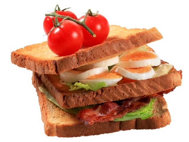 Сэндвич с яйцами, беконом и помидорами на белом фоне