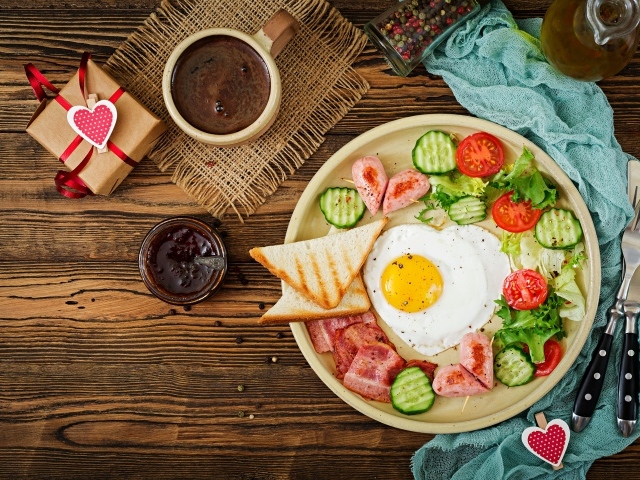 Яичница с беконом и овощами на столе с кофе к завтраку