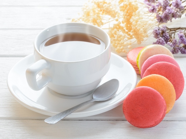 Белая чашка чая с макарунами