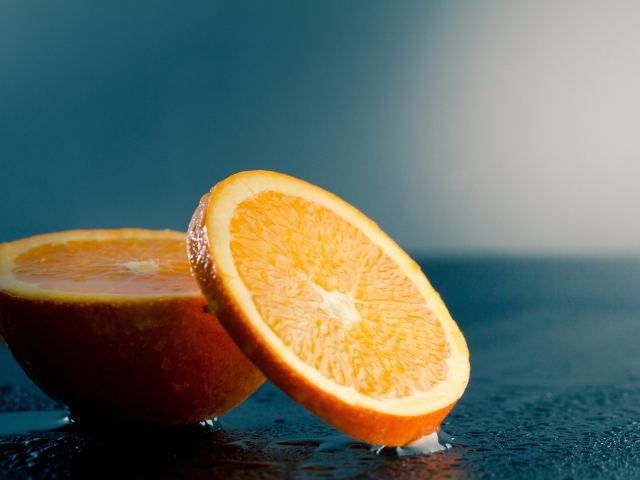 Оранжевый апельсин на мокром столе