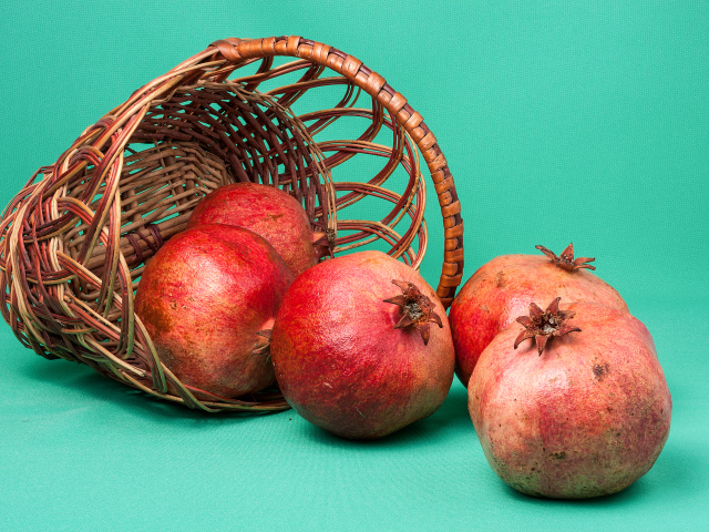 Плоды граната в корзине на голубом фоне