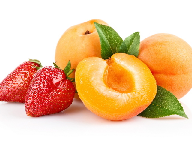 Спелые абрикосы с ягодами клубники на белом фоне