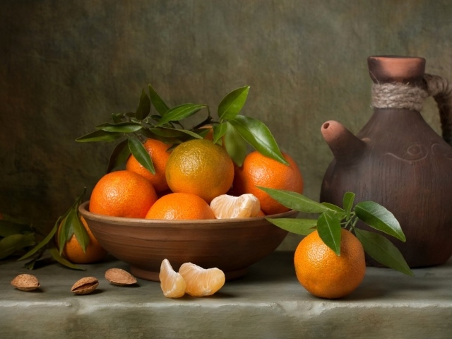 Спелые мандарины на столе с кувшином 