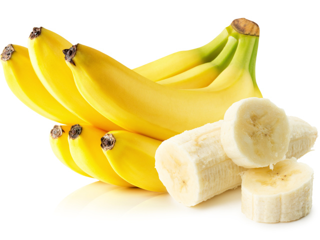 Спелые желтые бананы на белом фоне
