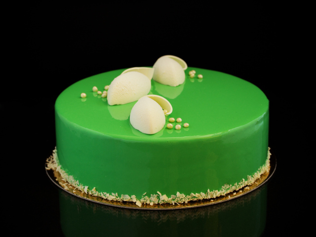 Зеленый глянцевый торт отражается в черной поверхности 