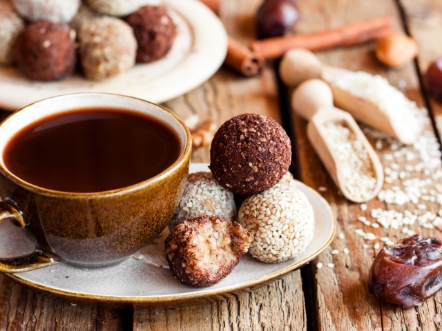 Большая чашка кофе с круглыми аппетитными конфетами