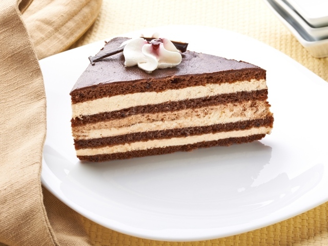 Большой кусок торта с кремом украшен цветком