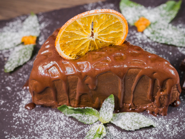 Кусок пирожного с шоколадом и кусочком апельсина