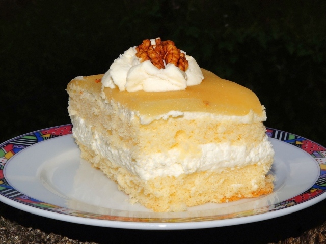 Кусок торта со сливочным кремом и грецкими орехами