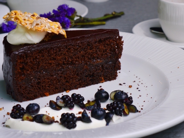 Кусок шоколадного пирога на большой белой тарелке
