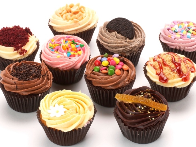 Аппетитные кексы с глазурью и сладкими добавками на белом фоне