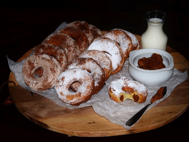 Аппетитные пончики со сгущенкой и свежим молоком на столе