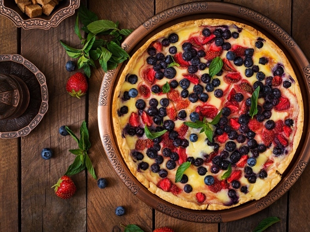 Аппетитный пирог с ягодами на деревянном столе