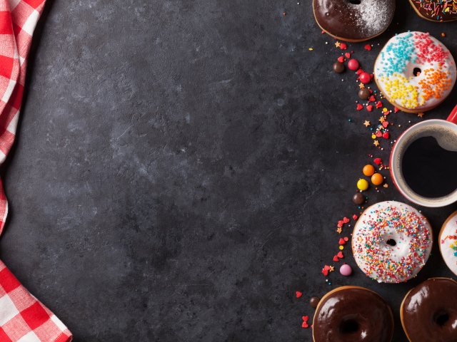 Аппетитные сладкие пончики с кофе на сером фоне