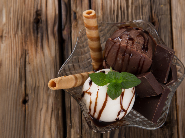 Шарик сливочного и шоколадного мороженого в пиале с трубочками