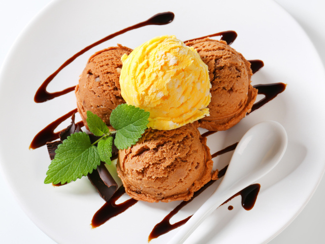 Шарики кофейного и фруктового мороженого на белой тарелке