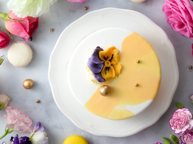 Красивый торт на белой тарелке с цветами вид сверху 