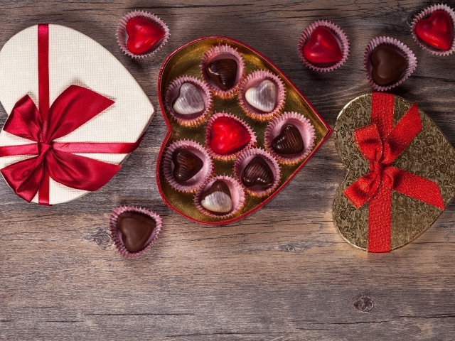 Коробки с шоколадными конфетами в форме сердца на столе 