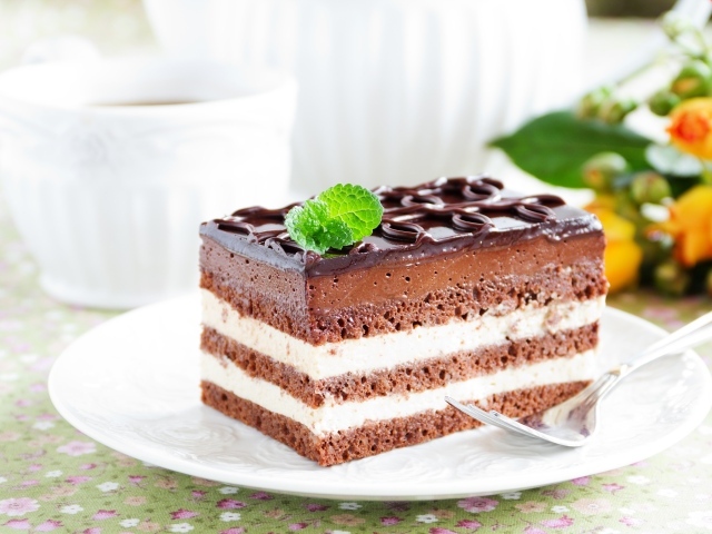 Пирожное с шоколадным и сливочным кремом на белой тарелке