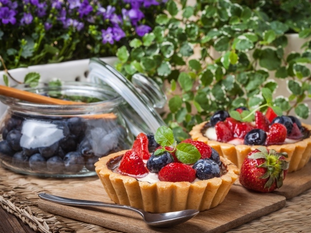 Пирожные с ягодами клубники и черники на столе