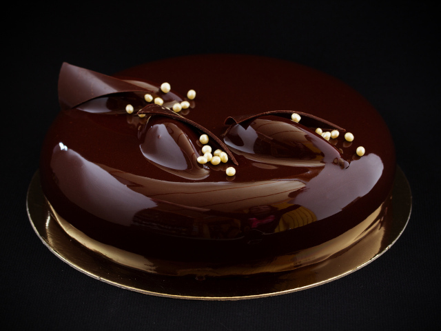 Шоколадный глянцевый торт на черном фоне 