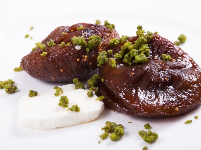 Инжир с фисташковыми орехами на белом фоне