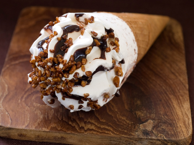 Мороженое рожок с шоколадом на разделочной доске