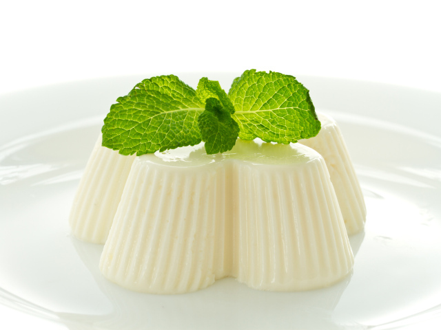 Молочное желе с мятой на белой тарелке 