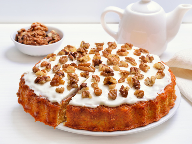 Пирог с кремом и грецкими орехами на столе с чаем
