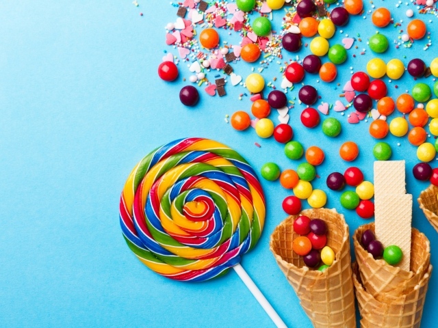 Сладкие конфеты и вафельные рожки на голубом фоне