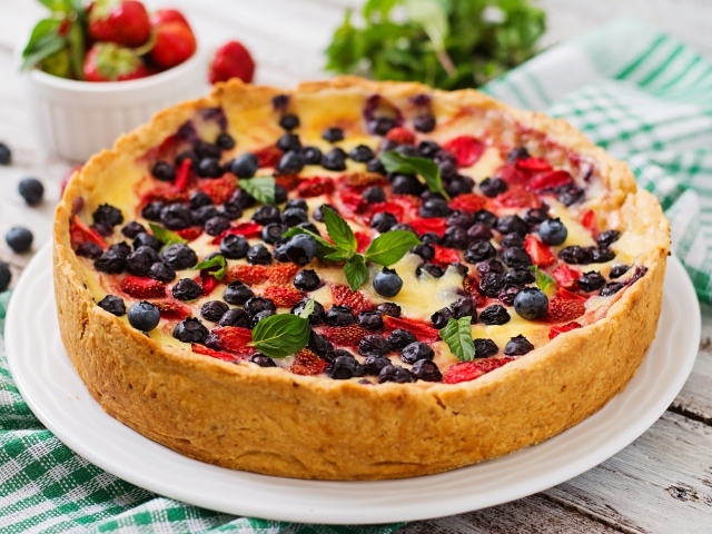 Сладкий пирог с черникой и клубникой на белом блюде