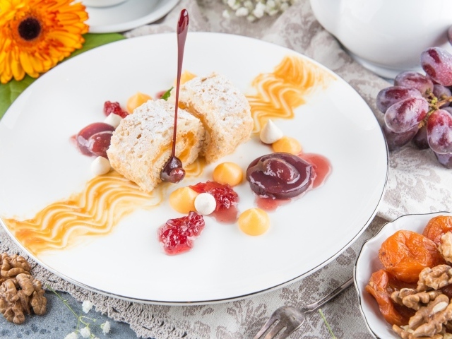 Сладкий рулет с сухофруктами и джемом на тарелке 