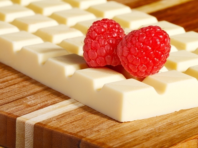 Сладкий белый шоколад с ягодами малины на столе