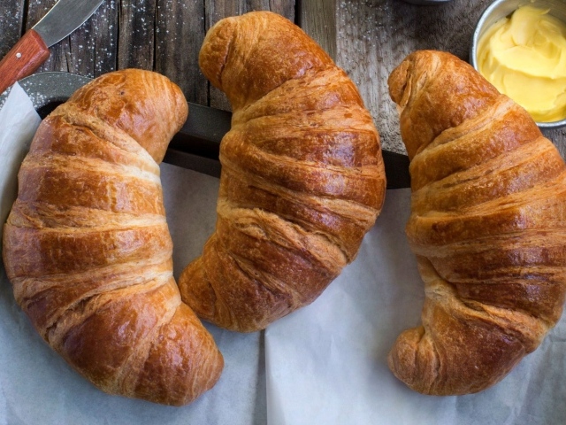 Три свежих круассана на столе с кремом 