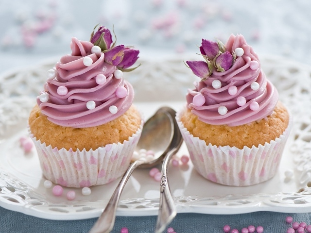 Два вкусных капкейка с кремом на тарелке