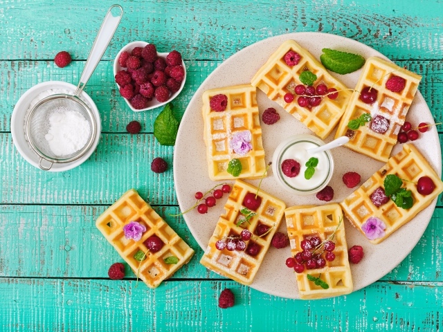 Вафли с малиной и красной смородиной на тарелке