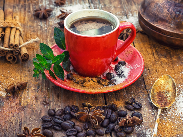 Чашка кофе на столе с зернами, корицей и зернами бадьяна 