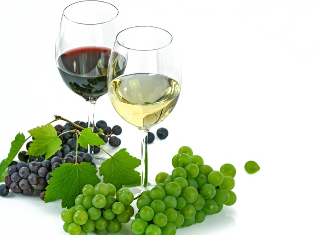 Бокал белого и красного вина на белом фоне с виноградом