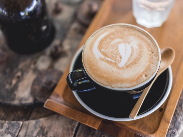 Большая чашка кофе с пеной на столе