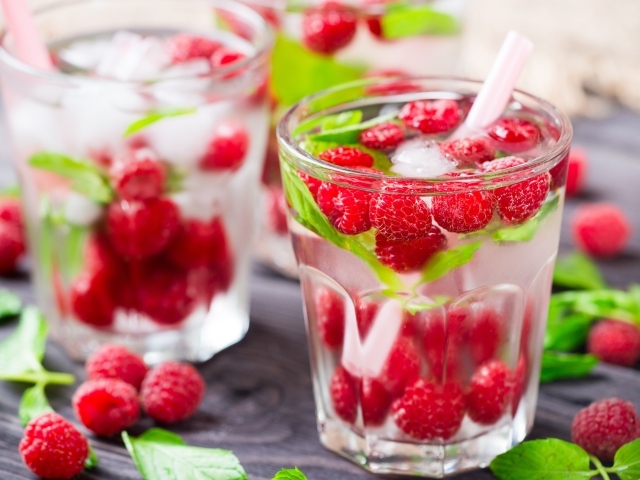 Напиток в стакане с малиной и кубиками льда