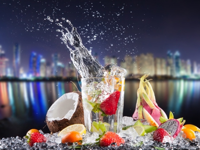 Напиток в стакане с тропическими фруктами на фоне ночного города