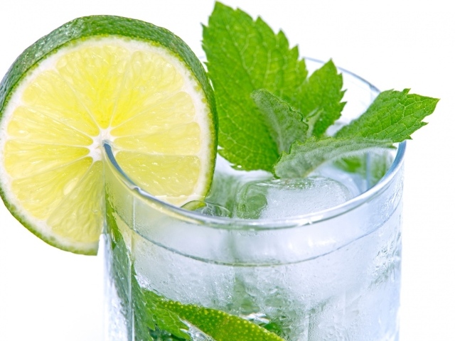 Стакан с освежающим напитком с мятой и лаймом на белом фоне