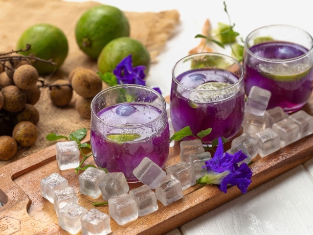 Стаканы с напитком на столе с лаймом и кубиками льда