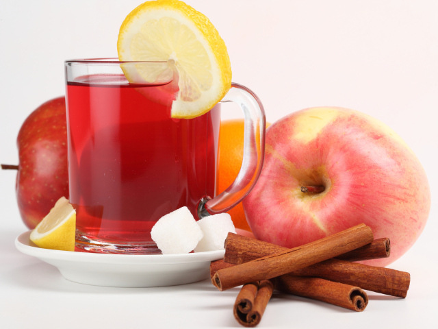 Чай с лимоном, яблоками и корицей на белом фоне